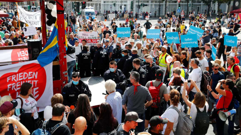 Police officers stand guard next to demonstrators during a rally against the government's restrictions following the coronavirus disease (COVID-19) outbreak, in Berlin, Germany August 29, 2020. REUTERS/Axel Schmidt