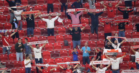 Hinchas de Sevilla con banderas y bufandas alientan a su equipo en la final de la Supercopa de Europa.