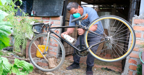 Manuel Narváez, padre de Jhonatan Narváez, posa con una bicicleta.