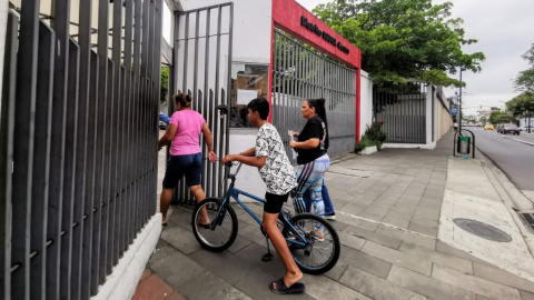 Padres de familia ingresas con un niño en bicicleta al distrito centro del Ministerio de Educación en Guayaquil.