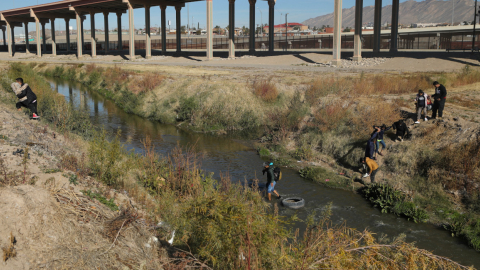 Un grupo de migrantes cruzando un tramo de la frontera entre México y Estados Unidos, en diciembre de 2022.