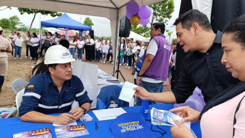 Personal de CNEL EP junto a dos ciudadanos en una feria de la empresa, realizada en Guayaquil, el 18 de mayo de 2024.