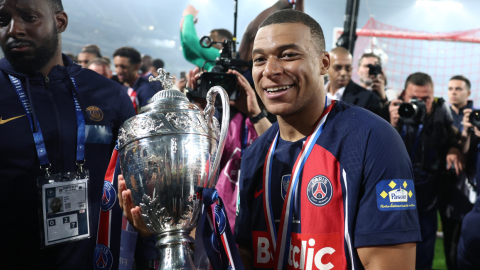 El delantero francés del París Saint Germain Kylian Mbappé celebra con el trofeo tras la victoria de su equipo en la final de la Copa de Francia, el 25 de mayo de 2024.