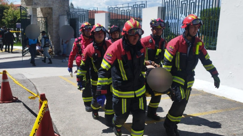 Miembros del Cuerpo de Bomberos de Quito trasladan a uno de los heridos en Monteolivo, el 2 de junio de 2024.