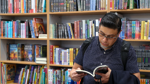 Una persona lee un libro es un stand de la Feria Internacional del Libro de Quito (FILQ), el 11 de junio de 2024.