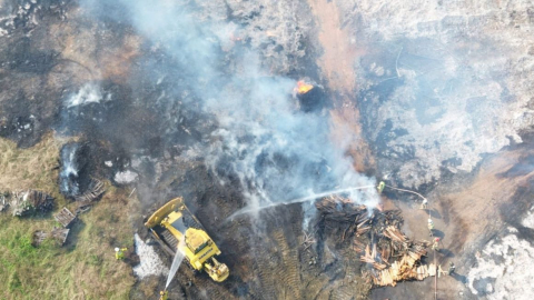 Maquinaria del Municipio de Guayaquil y bomberos en el incendio de una fábrica de pallets en la vía a Durán, Guayaquil, el 26 de junio de 2024.