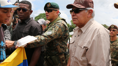 El presidente electo de Panamá, José Raúl Mulino (d), habla con un migrante el 28 de junio de 2024, en el albergue para migrantes de Lajas Blancas, en el Darién.