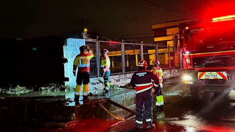 Bomberos de Quito realizan tareas de limpieza en una vía con acumulación de agua, este 28 de junio de 2024.