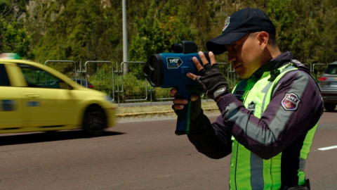 Agente de tránsito utiliza un cinemómetro para controlar el exceso de velocidad.