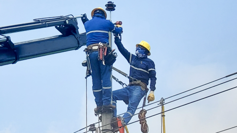 Personal de CNEL realiza trabajos de reparación en un poste de luz.