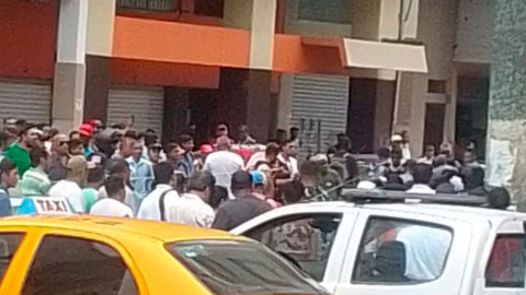 Ciudadanos observan el procedimiento de la Policía tras una balacera en el centro de Guayaquil