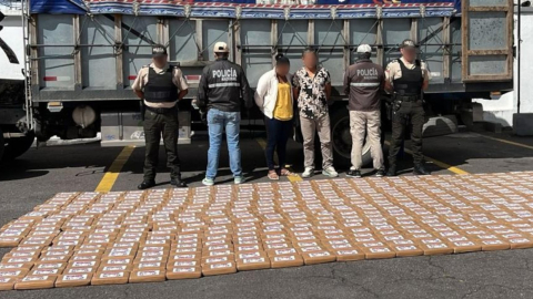 Policías junto a dos detenidos por transportar cocaína en un camión en el sector de Tandapi, el 143 de julio de 2024.