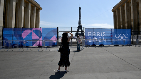 Una mujer posa en el Trocadero frente a la Torre Eiffel parcialmente oculta por una valla, antes de los Juegos Olímpicos de París 2024, el 19 de julio de 2024.