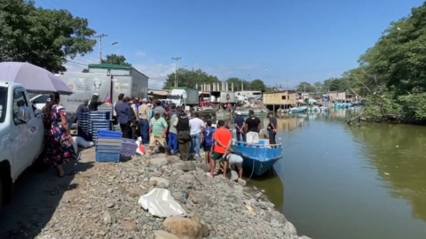 Un grupo de personas observa los cuerpos de los pescadores asesinados este 22 de julio de 2024 en Bajo Alto, provincia de El Oro.