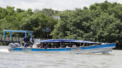 Migrantes se trasladan en lancha, el 8 de julio de 2024, en Turbo (Colombia) hacia la selva del Darién.