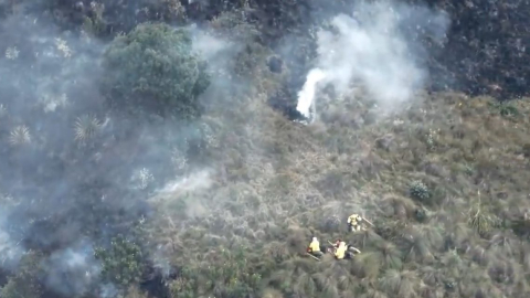 Bomberos y brigadistas atienden un incendio forestal en Pucán, Cuenca, en la tarde del 29 de julio de 2024.