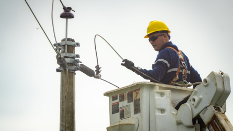 Técnico de CNEL realiza trabajos en un poste de luz.