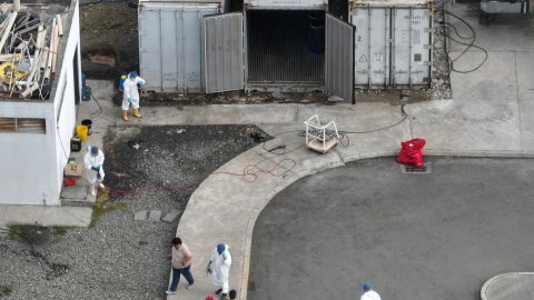 Personal desinfecta un contenedor con cadáveres sin identificar, luego de fallas en el sistema de refrigeración en el Laboratorio de Criminalística y Ciencias Forenses de Guayaquil, el 13 de junio del 2024.