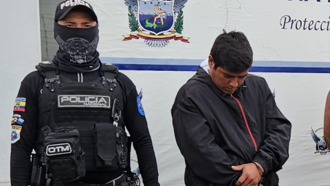 Un policía junto a Jesús S., alias ‘Güico’, quien fue detenido este 20 de agosto en Durán por posesión de armas, vehículos robados y placas.