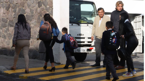 Personas caminan hacia una institución educativa de Quito el 2 de septiembre de 2024, en el día del inicio de clases del año lectivo en la Sierra.