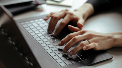 Persona escribiendo en el teclado de una laptop. Imagen referencial.