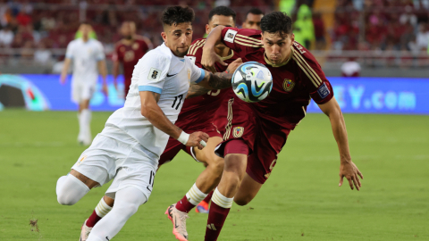 Nahuel Ferraresi de Venezuela disputa un balón con Cristian Olivera Ibarra de Uruguay, el martes 10 de septiembre, por la Fecha 8 de Eliminatorias, en el estadio Monumental de Maturín.