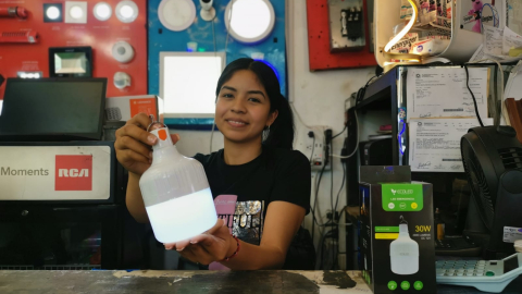 Carla Litardo, de iluminación Molina, en el centro de Guayaquil, muestra un modelo de bombillo recargable que se comercializa en el sector de la calle Rumichaca desde USD 4.50.