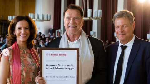 En el centro, Arnold Schwarzenegger mostrando su título de doctor honoris causa de la Universidad Hertie de Berlín.