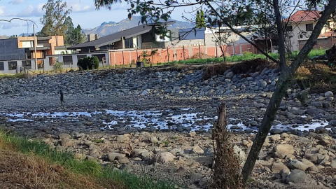 Un adolescente juega entre las piedras del río Tomebamba, en Cuenca, ante la escasa agua debido a la sequía hidrológica.