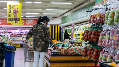 Mujer seleccionando frutas en Supermercados Santa María