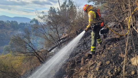 Un bombero apaga un incendio en el sector del puente del Chiche, en Quito, el 17 de septiembre de 2024.