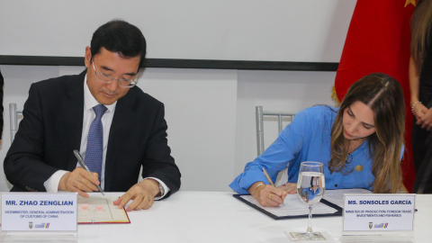 Viceministro de la Administración General de Aduanas de China, Zhao Zenglian, y la ministra de Producción de Ecuador, Sonsoles García, firman un memorando sobre inocuidad alimentaria.