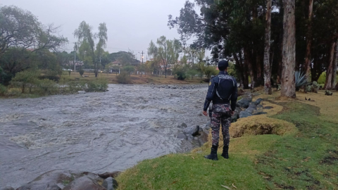 Un policía municipal observa la corriente del río Tomebamba de Cuenca, el 29 de septiembre de 2024.