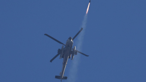 Un helicóptero apache israelí dispara un misil hacia objetivos en el sur de Líbano, mientras es observado desde la tierra en el norte de Israel, el 4 de octubre de 2024.