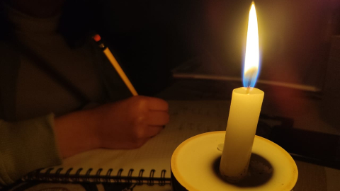 Una estudiante realiza tareas con ayuda de una vela, ante los cortes de luz. Habrá suspensión del servicio el 6 de octubre en Cuenca.