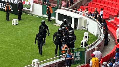 La Policía camina con el detenido por las detonaciones en el partido entre Liga de Quito y Orense, el domingo 6 de octubre de 2024.