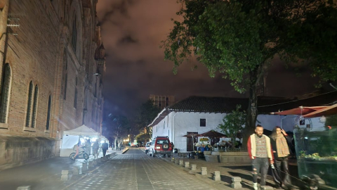 Una calle Cuenca transitada por peatones en medio de un corte de luz.