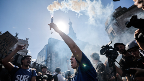 Una mujer grita mientras carga una bengala durante una manifestación en Argentina, 9 de octubre de 2024.