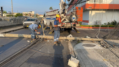 Trabajadores de CNEL reparan un poste de luz eléctrica en Guayaquil, el 24 de agosto de 2024