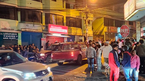 Moradores en los exteriores de una farmacia atacada con armas de fuego en La Roldós, en el noroccidente de Quito.