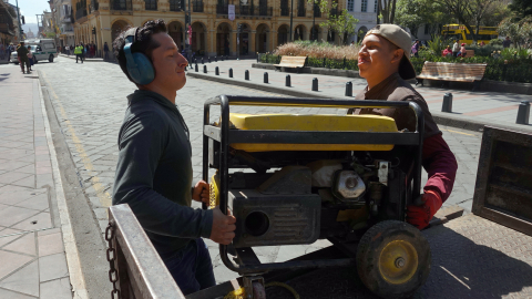 Ciudadanos mueven un generador de energía eléctrica para abastecer a un local comercial de Cuenca en medio de cortes de luz, en octubre de 2024.