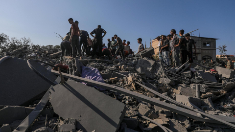 Palestinos buscan entre los escombros de una casa destruida por un ataque aéreo israelí en un campamento de refugiados en la Franja de Gaza, el 17 de octubre de 2024.