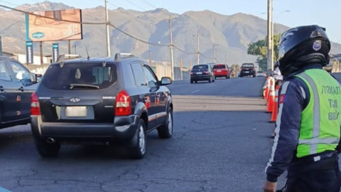 Un agente metropolitano dirige el tránsito en una de las calles de Quito  y verifica el cumplimiento del Pico y Placa.