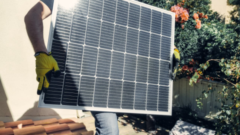 Fotografía referencial de un contratista instalando un panel fotovoltaico para que un hogar cuente con energía solar.