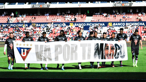 Los jugadores de Liga de Quito sostienen una bandera en el estadio Rodrigo Paz Delgado, el 26 de octubre de 2024.