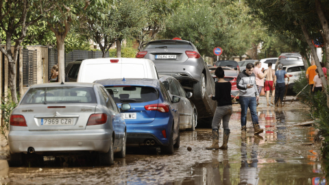 Varias personas junto a vehículos dañados por las intensas lluvias de la fuerte DANA que afecta especialmente el sur y el este de la península ibérica, el 30 de octubre de 2024 en Picaña.