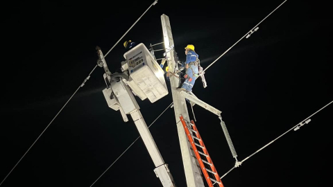 Técnicos de CNEL realizan trabajos en un poste de alumbrado público.