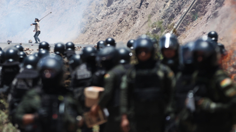 Un hombre se enfrenta con miembros de la Policía Militar Boliviana durante un bloqueo por simpatizantes del expresidente de Bolivia, Evo Morales (2006-2019) este viernes, en Parotani (Bolivia). Un gran contingente de policías y militares bolivianos desbloquean las carreteras tomadas por los seguidores de Morales desde hace 19 días, medida que ejercen en defensa de su líder ante una posible orden de captura en su contra por un caso de trata de personas y estupro.