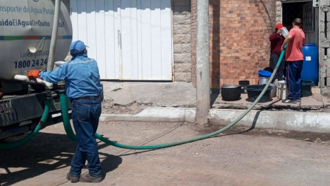 Una moradora de Quito recibe agua potable en un tanquero.