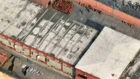 Una vista aérea de cuerpos cubiertos con mantas y de prisioneros sometidos en el pabellón 3 de la Penitenciaría del Litoral de Guayaquil, tras enfrentamientos que se saldaron con 15 reclusos muertos